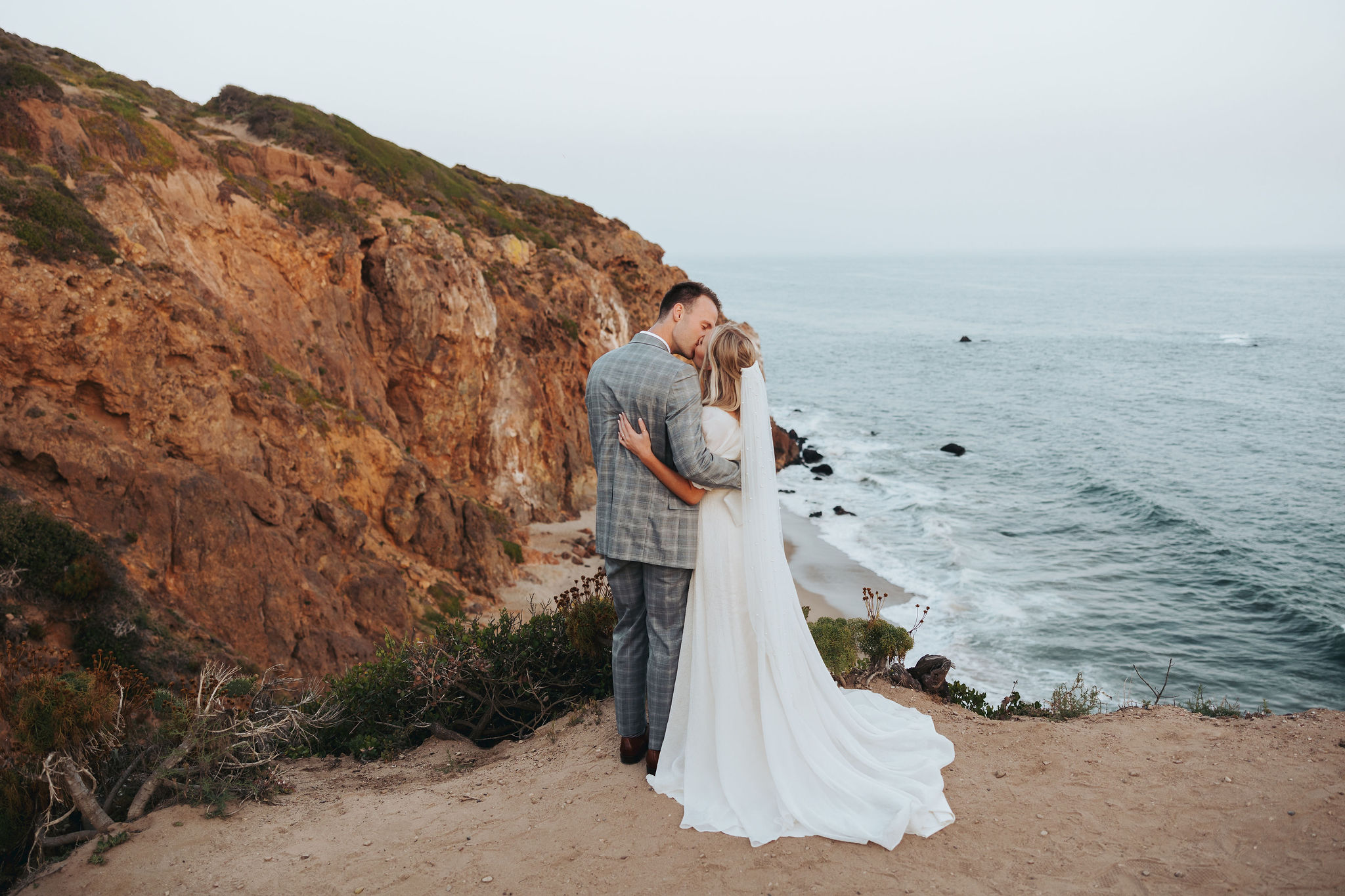 bride and groom kissing on a beach at Point Dume