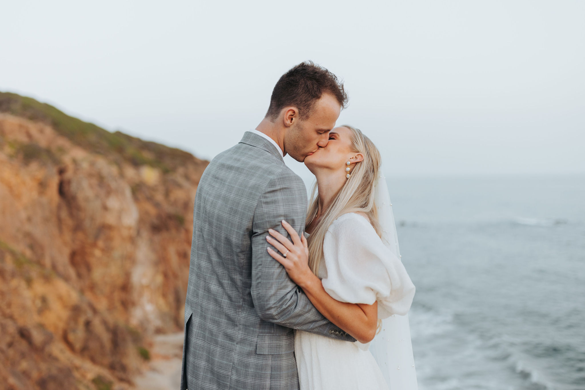 bride and groom kissing on a beach