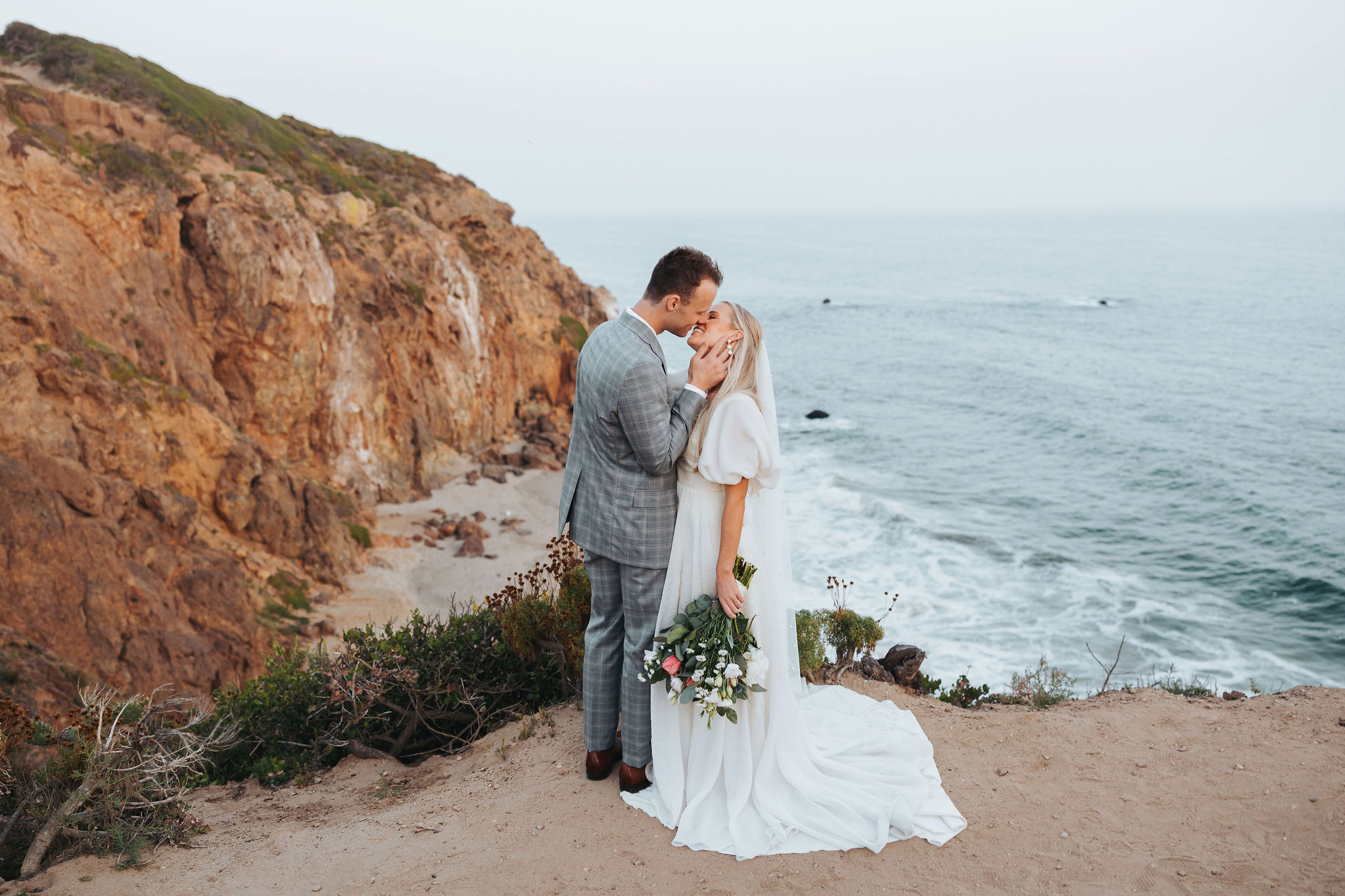 bride and groom kissing on a beach at Point Dume