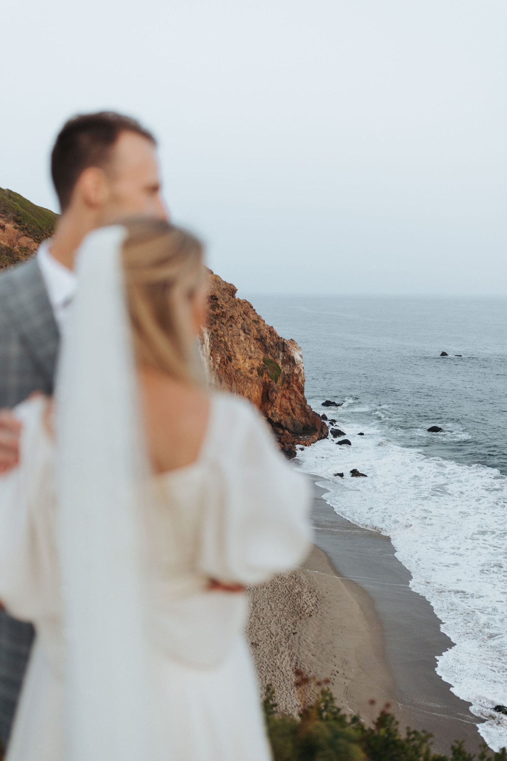 bride and groom hugging on a beach at Point Dume