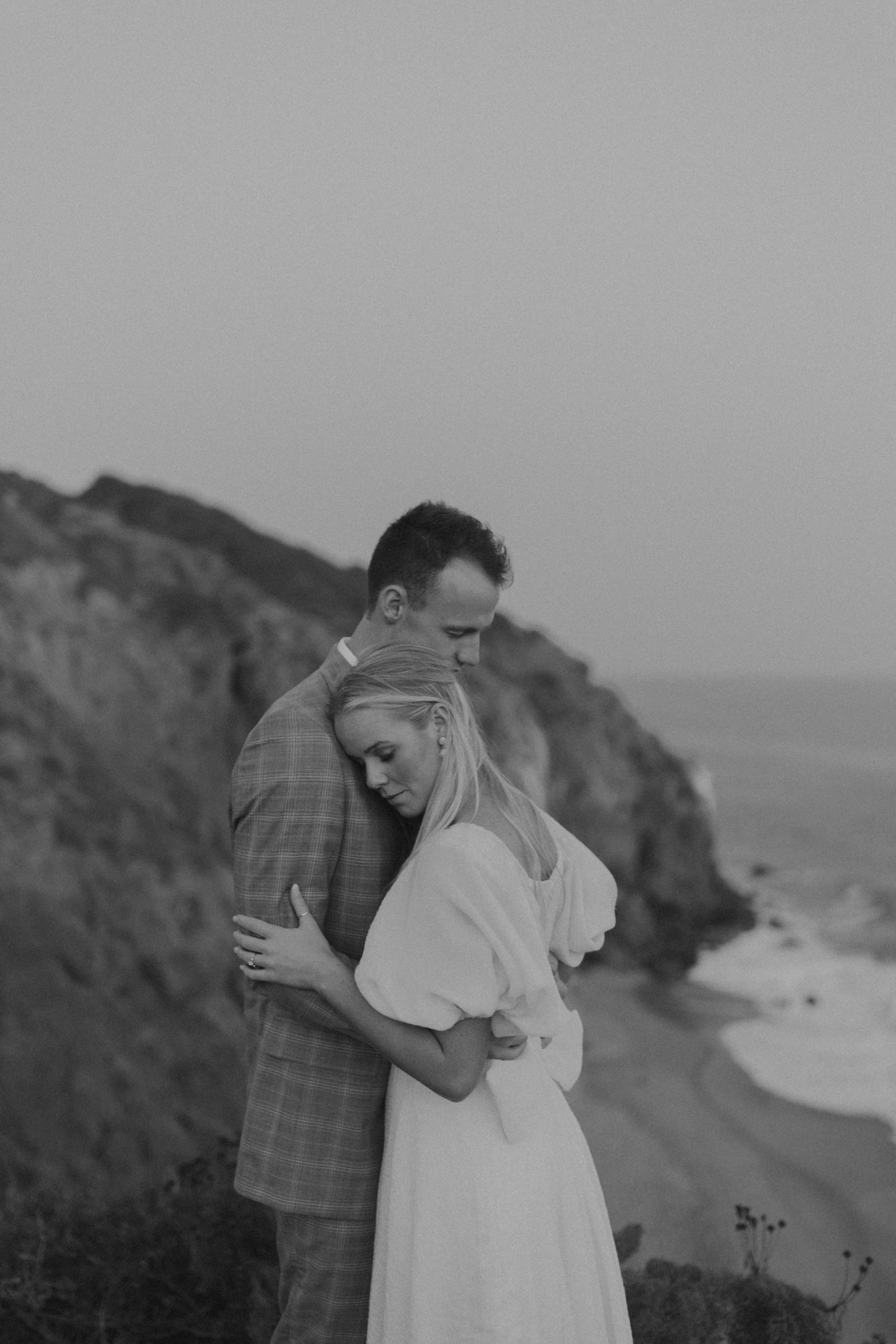 bride and groom hugging on a beach
