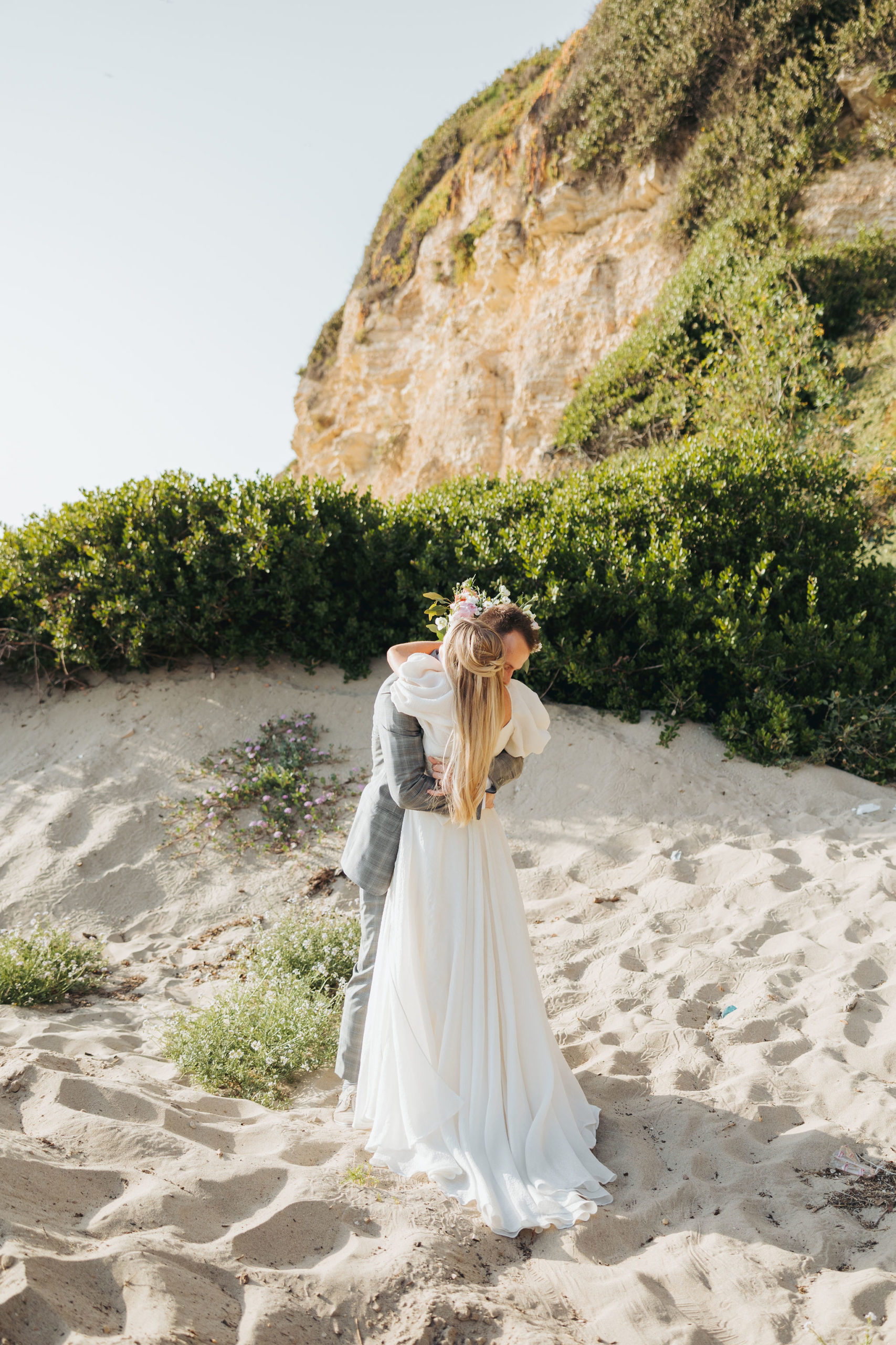 bride and groom holding hugging on a beach