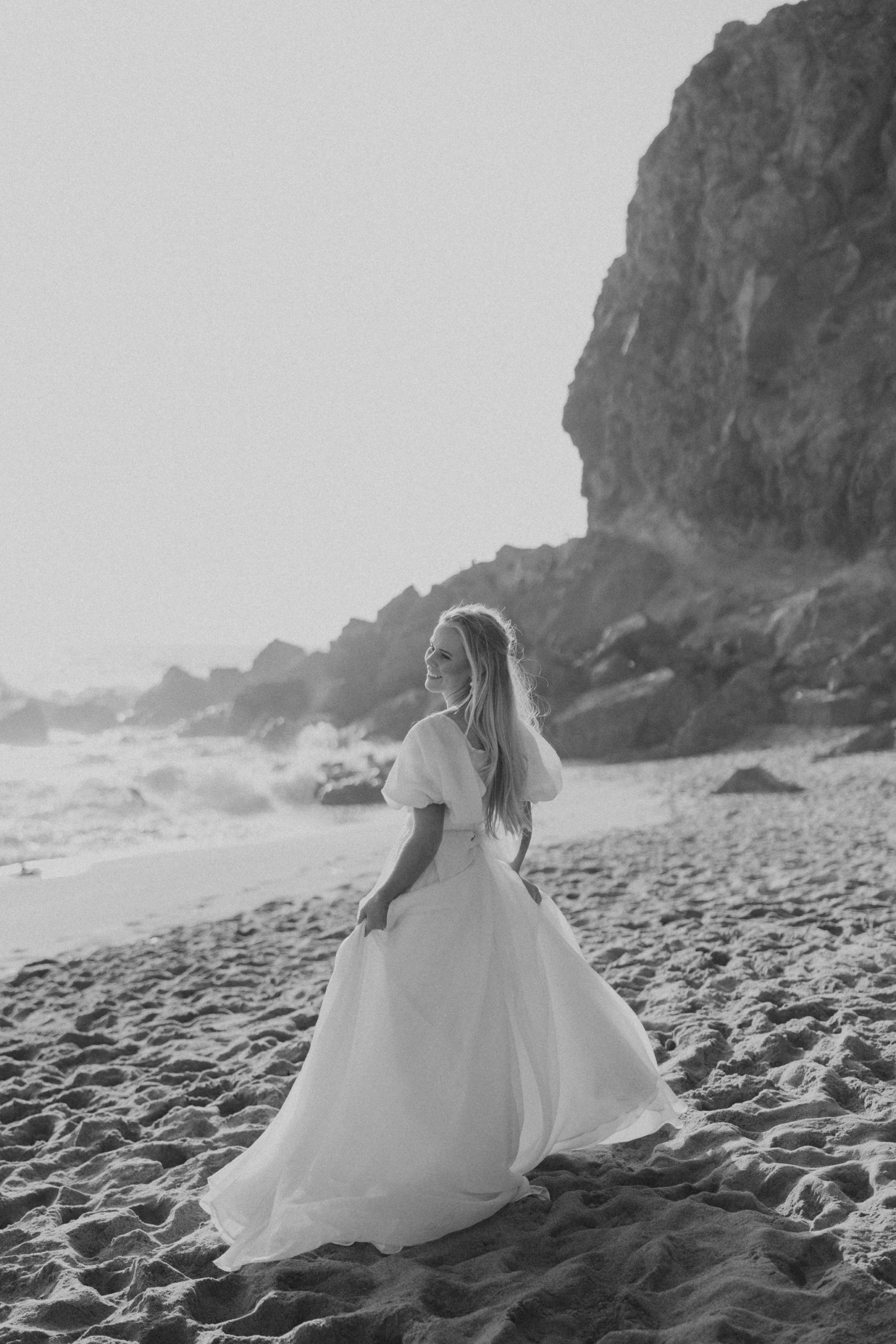 bride walking on a beach in front of rocky cliff at Point Dume