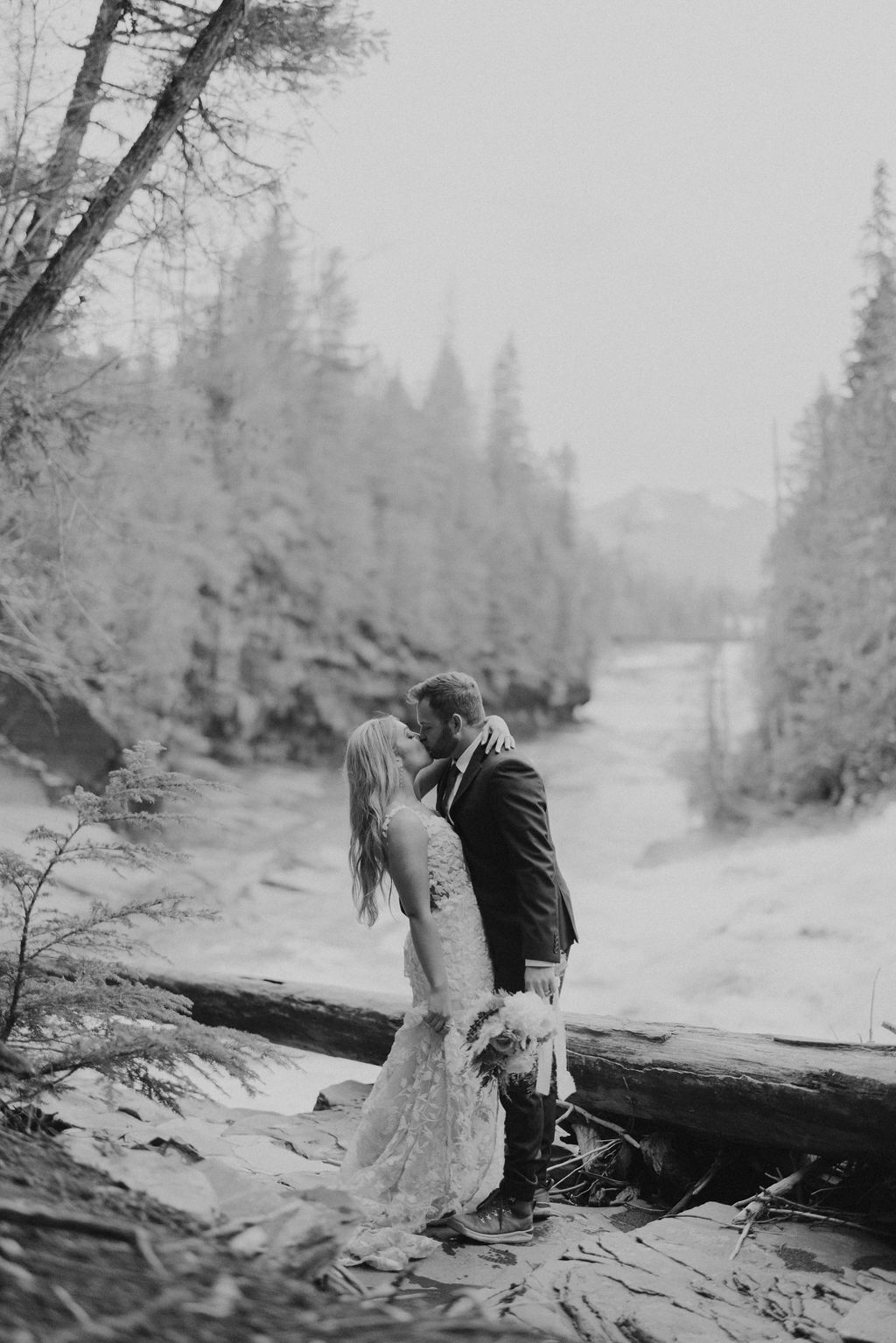 bride and groom portraits at glacier national park in front of waterfall