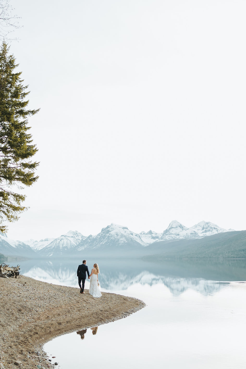 bride and groom portraits at glacier national park in front of lake