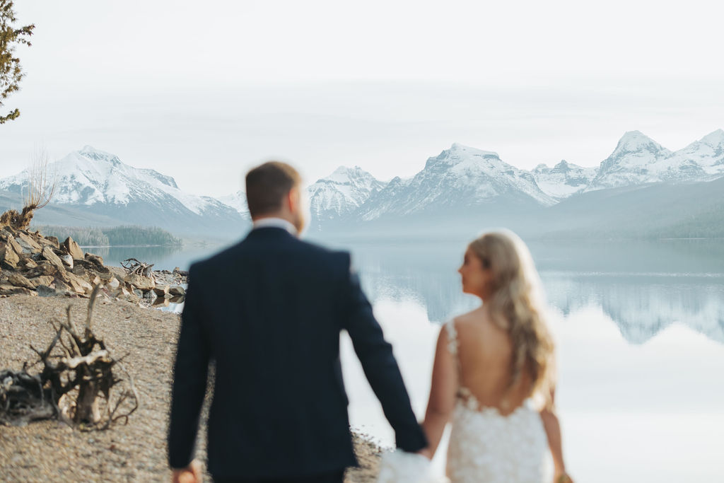 bride and groom portraits at glacier national park in front of lake