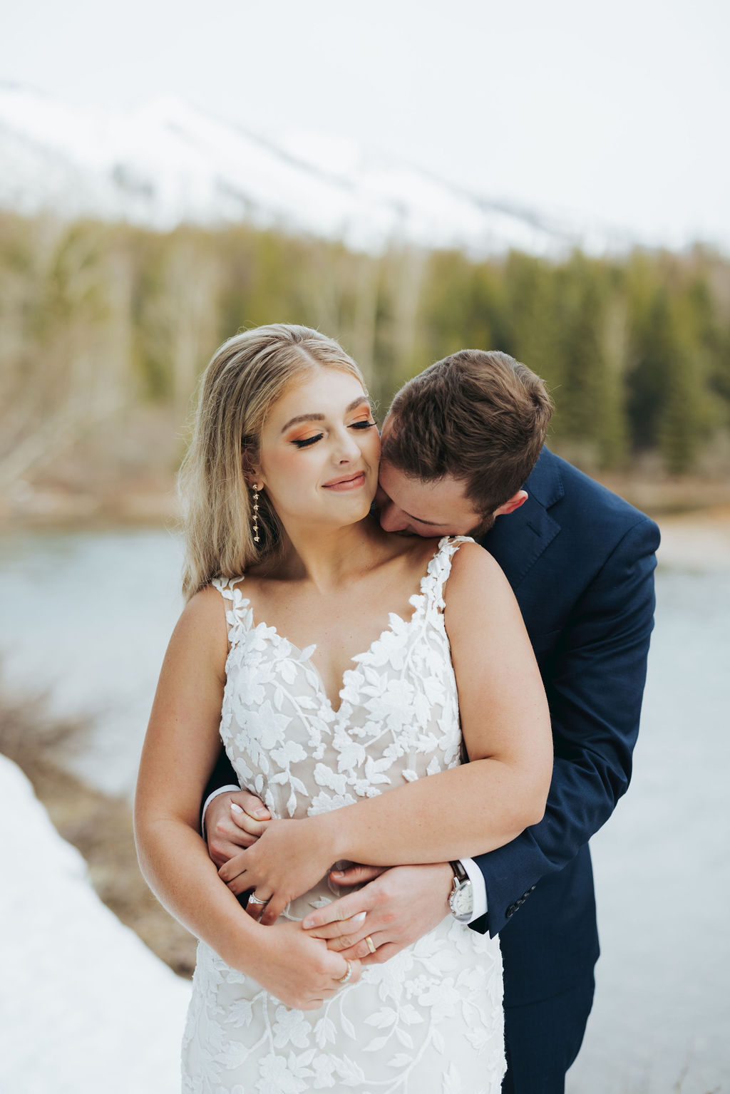 bride and groom portraits at glacier national park in front of trees