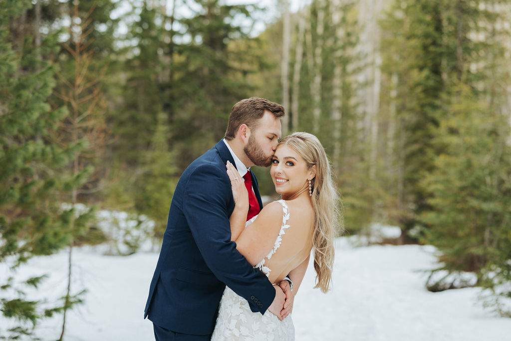bride and groom portraits at glacier national park in front of trees