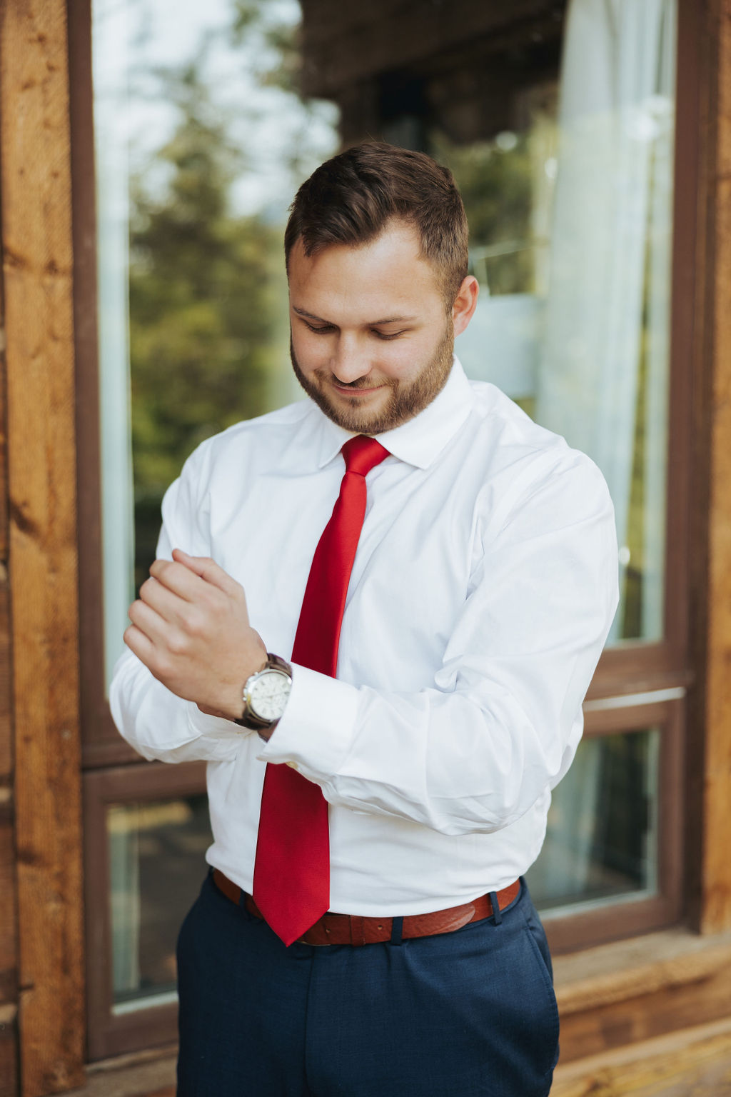 groom portrait in front of cabin with blue suit