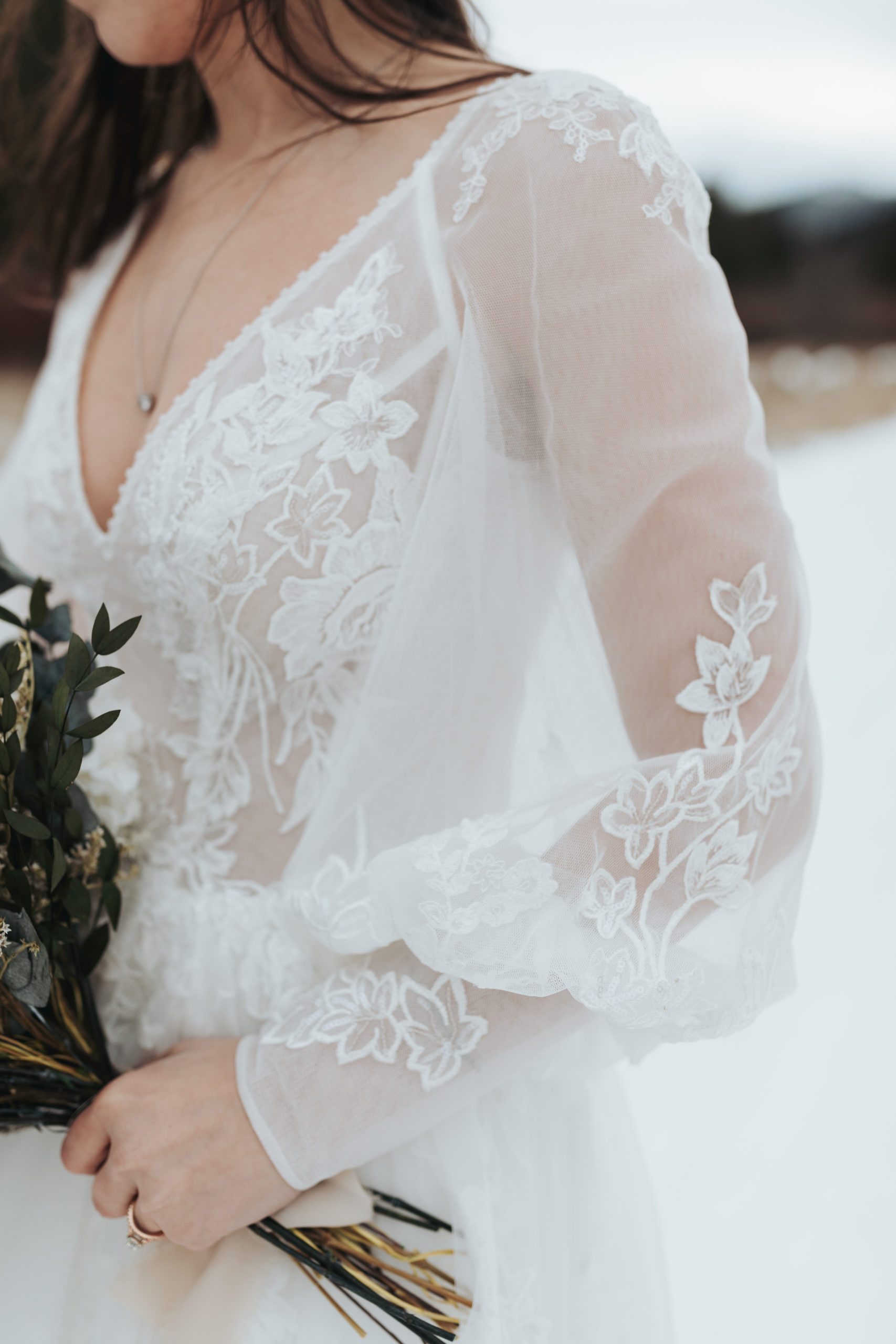 bride walking in snow with eucalyptus bouquet after elopement ceremony in grand teton national park 
