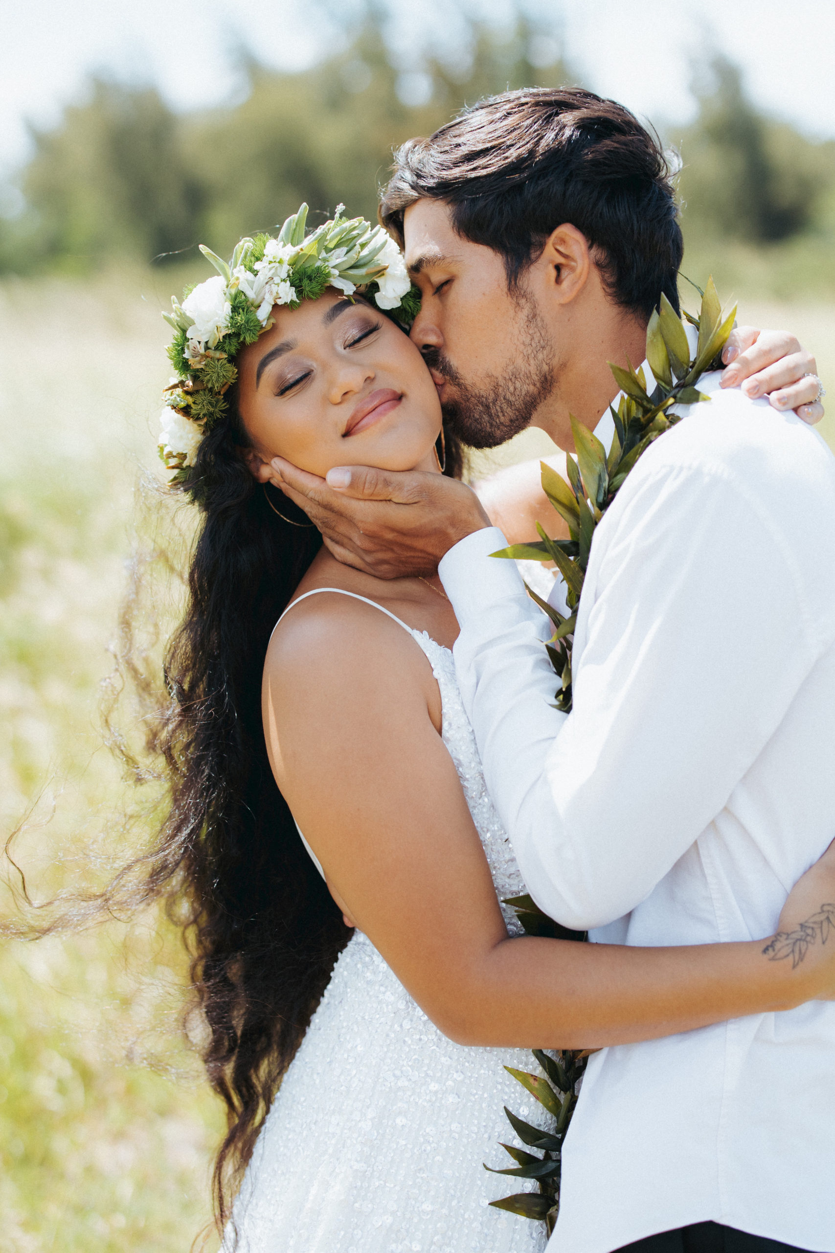 bride and groom kissing in a field elopement portrait in maui hawaii