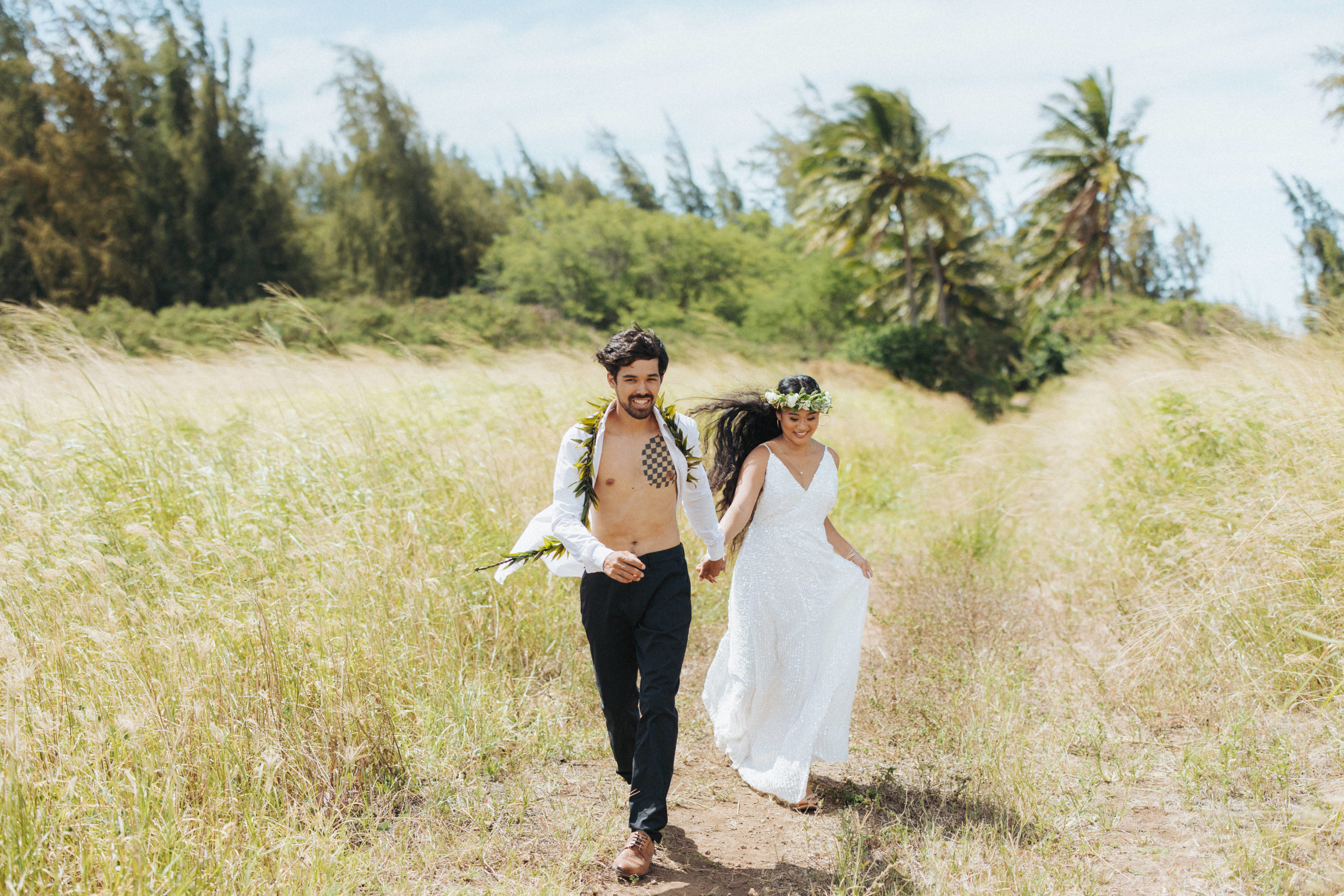 bride and groom running in a field elopement portrait in maui hawaii