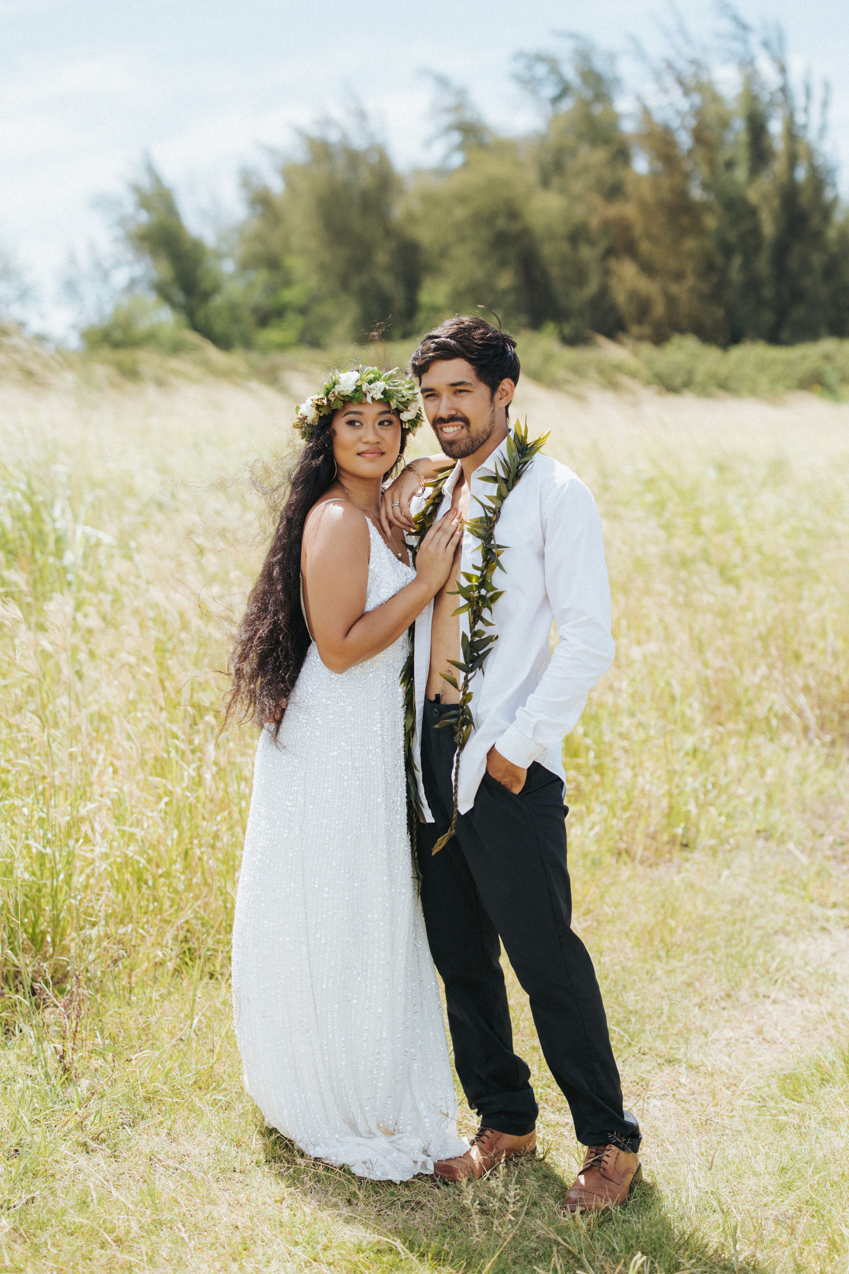 bride and groom standing in a field couple portrait in maui hawaii