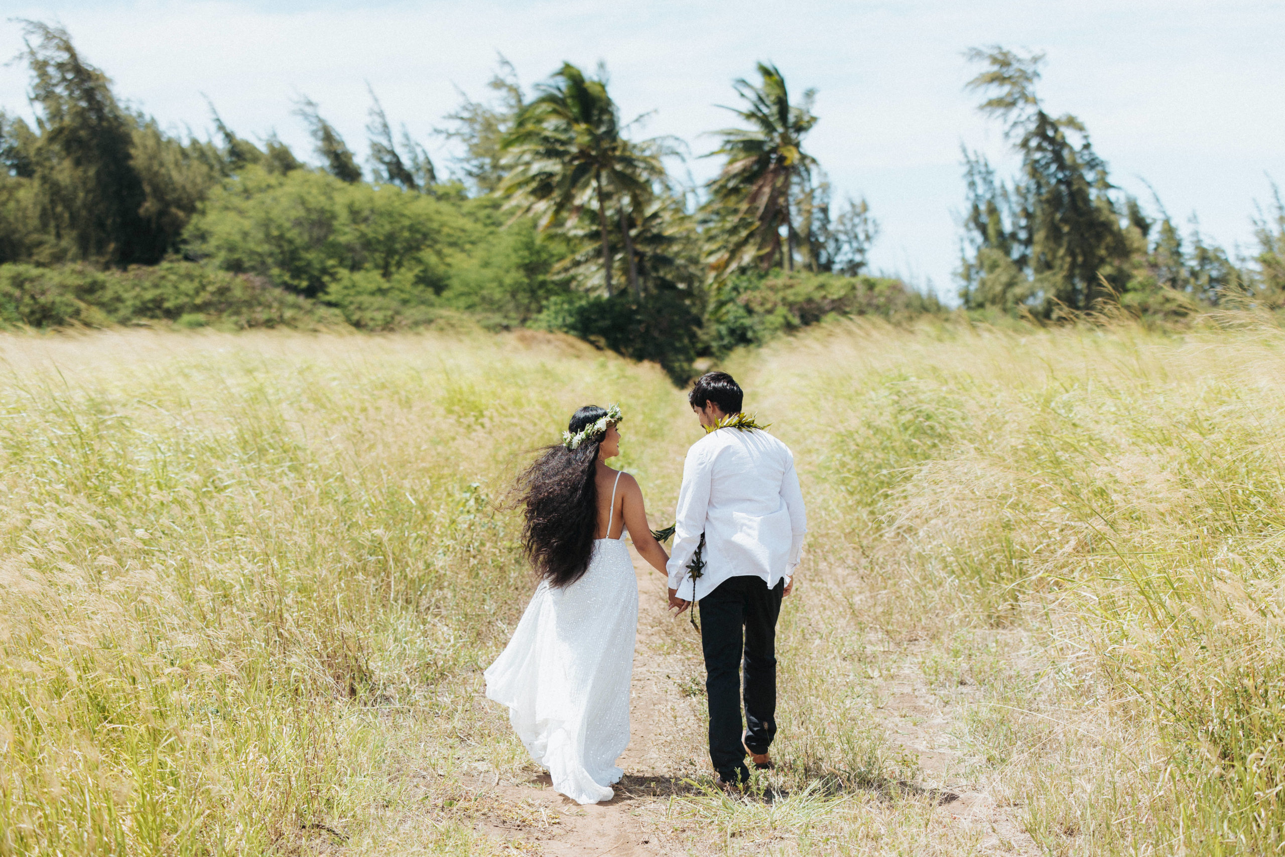 bride and groom walking in a field elopement portrait in maui hawaii