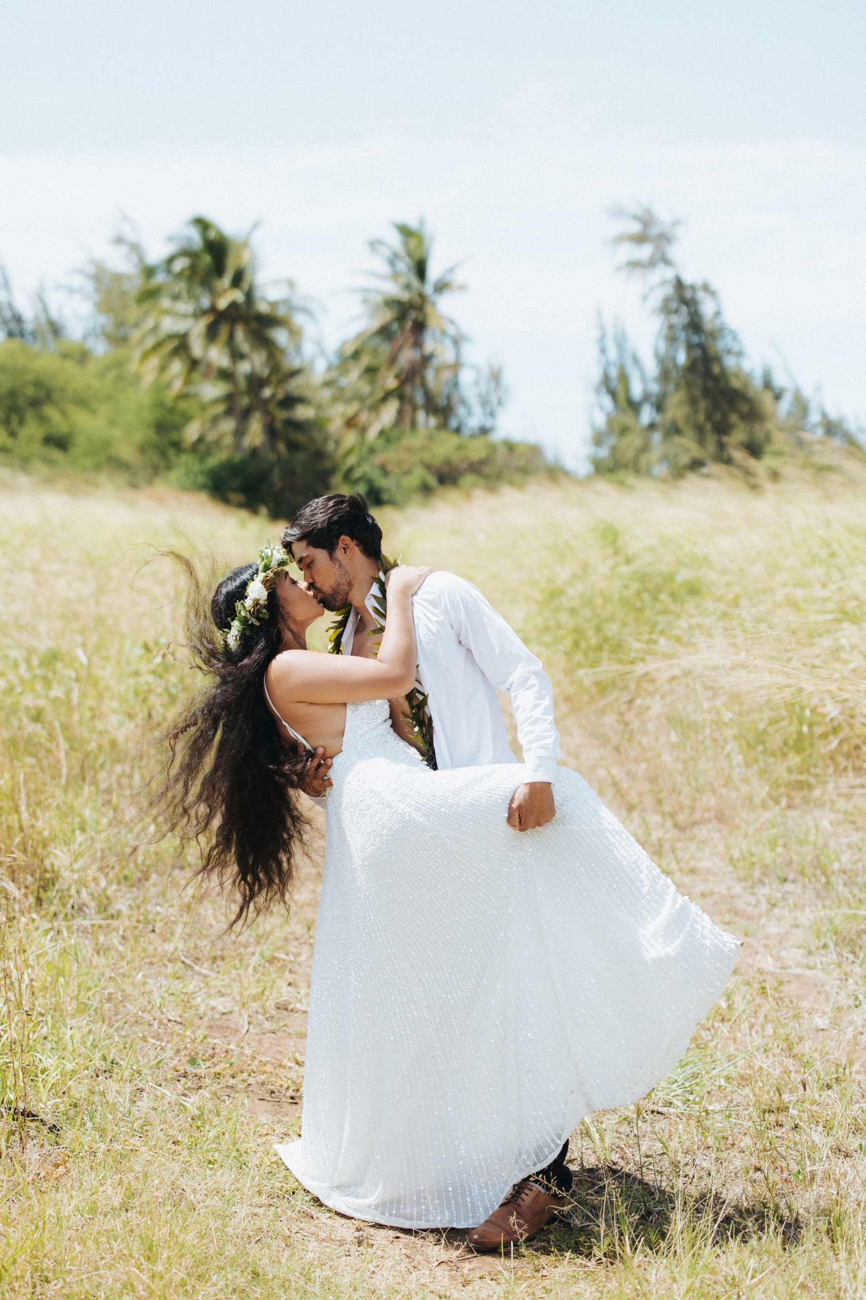 bride and groom kissing in a field couple portrait in maui hawaii