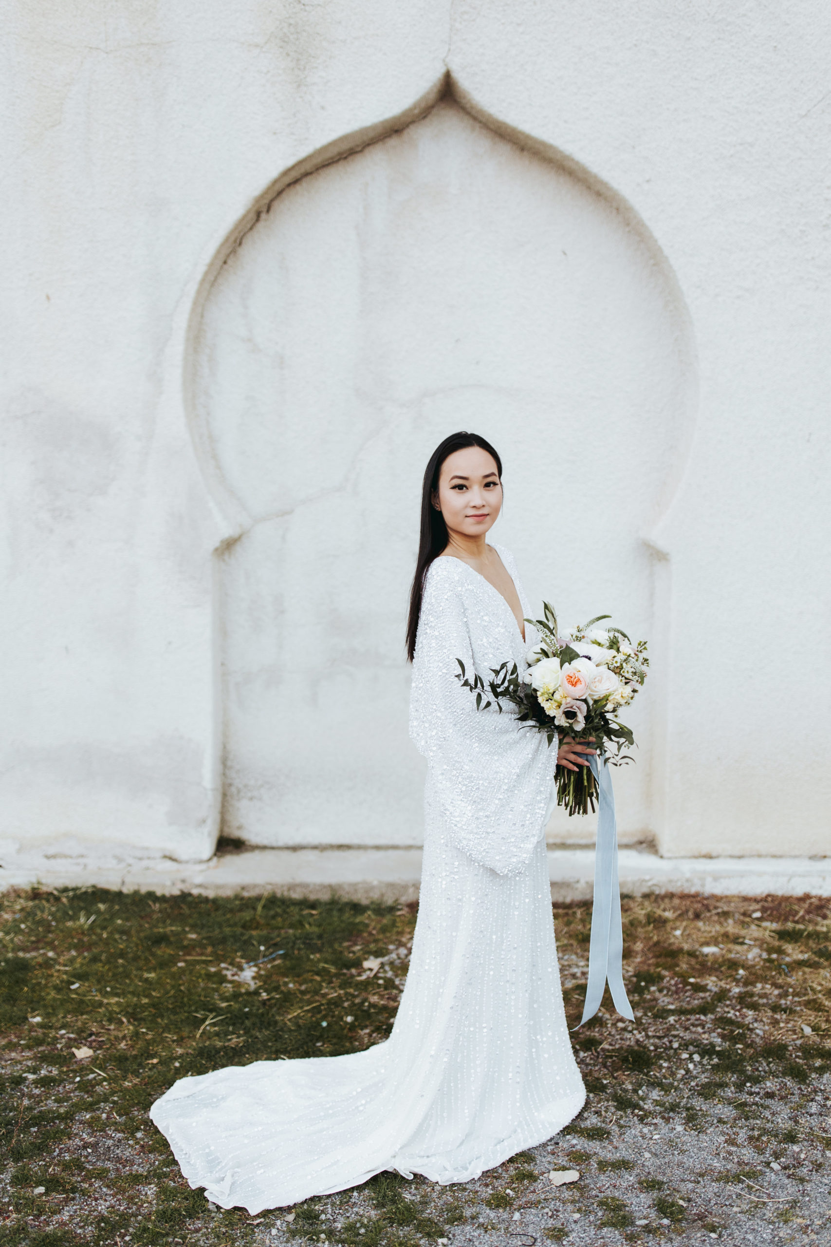 bridal portrait in front of concrete wall wearing a glitter wedding dress