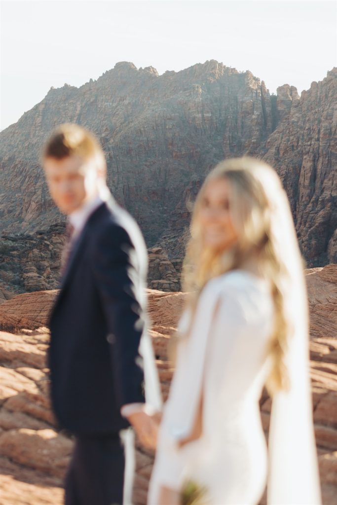 bride and groom elopement portraits walking in canyon