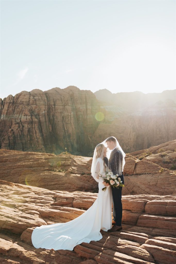 bride and groom canyon elopement portraits kissing during an adventure session at Snow Canyon
