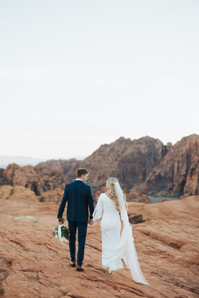 bride and groom walking during an adventure session at Snow Canyon