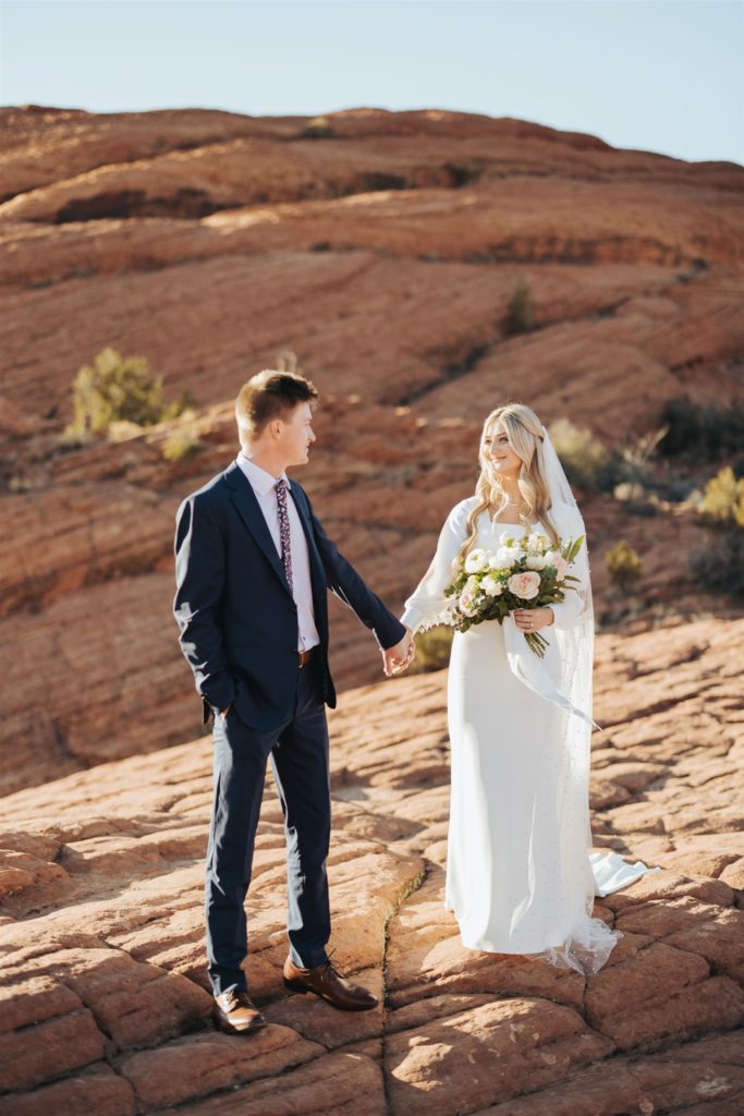 bride and groom elopement portraits walking in canyon