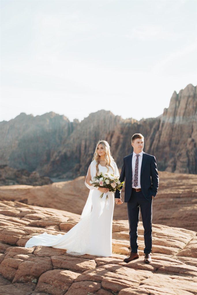 bride and groom elopement portraits walking in canyon during an adventure session at Snow Canyon