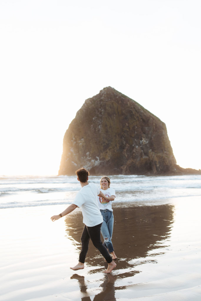 couple running on the beach in Cannon Beach Oregon