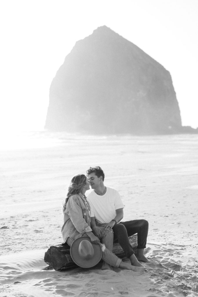 couple cuddling on the beach in Cannon Beach Oregon