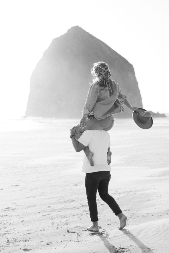 woman on man's shoulders at the beach in Cannon Beach Oregon