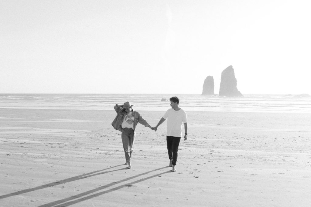 couple walking on the beach holding hands in Cannon Beach Oregon