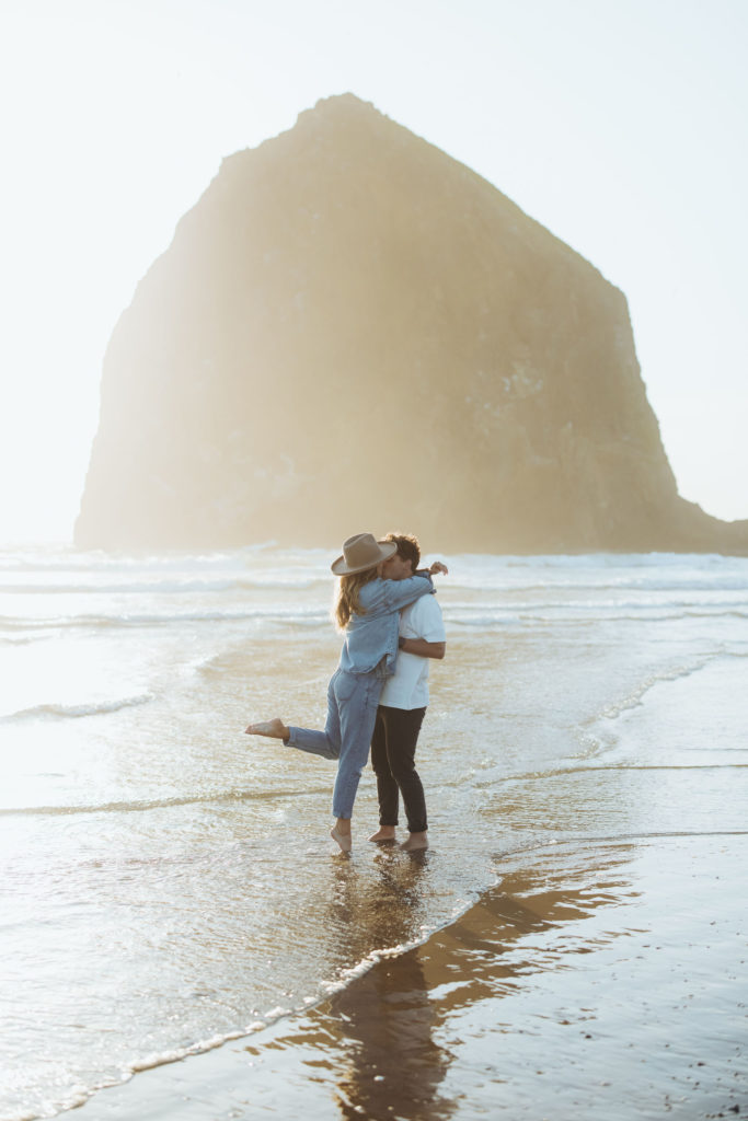 couple kissing on the beach in Cannon Beach Oregon