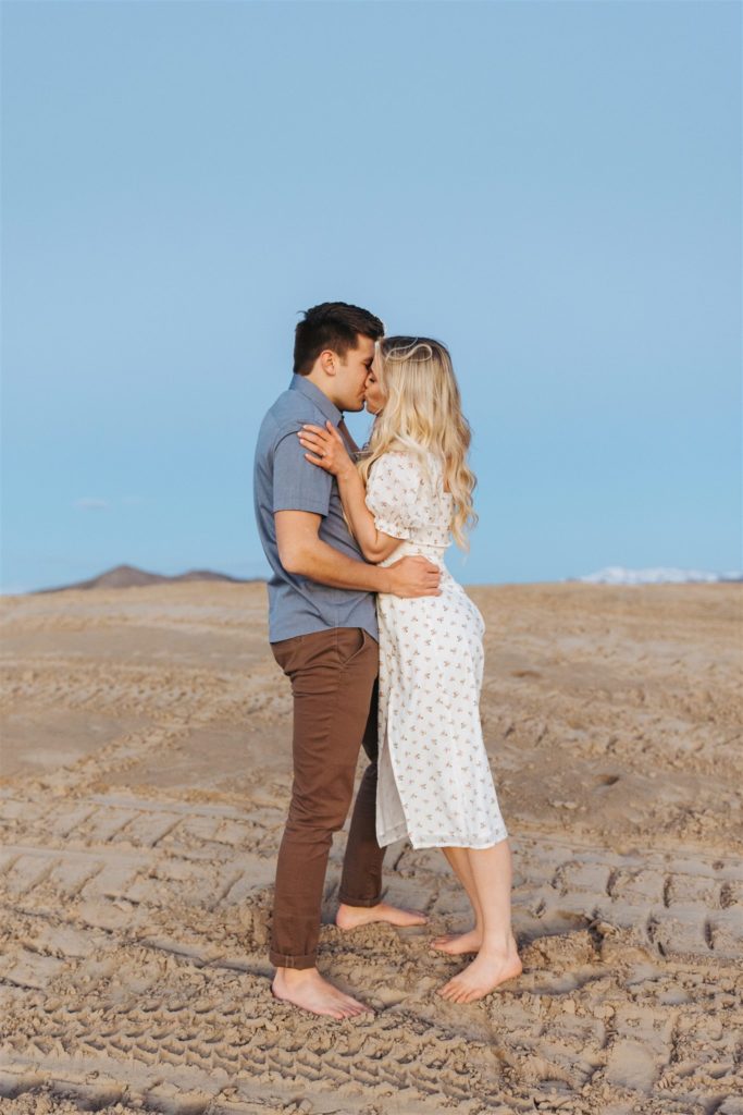 Couple kissing on sand dune