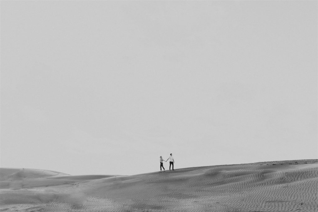 Couple walking on sand dune
