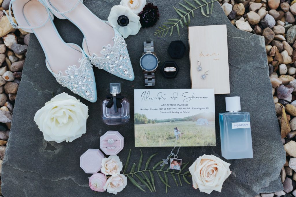 wedding details with shoes and perfume and invitation