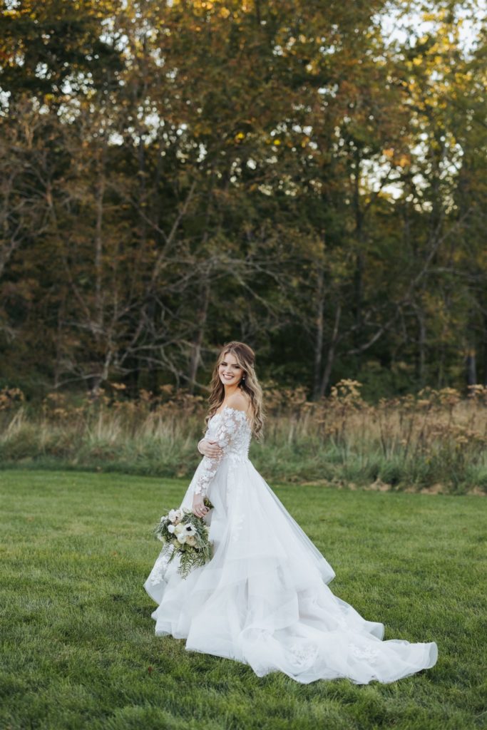 bride with lace wedding dress in a field