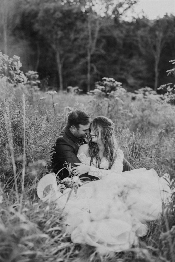 bride and groom hugging in a field