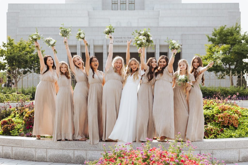 bride with bridesmaids in front of the temple at Draper Temple in Utah
