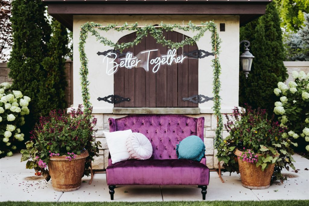 wedding photobooth backdrop with purple velvet couch at Le Jardin wedding venue in Draper Utah
