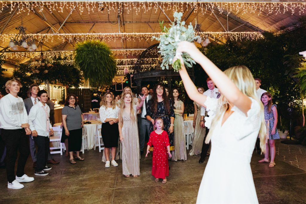 bridal bouquet toss at wedding reception 