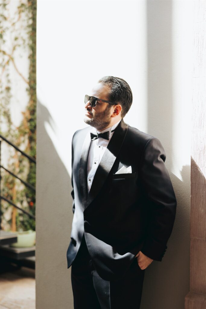 groom portrait in black suit with black tie and sunglasses