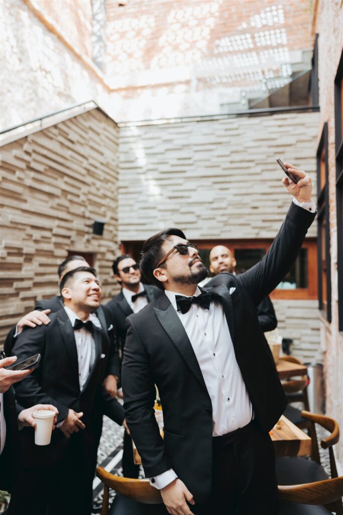 groomsman selfie in black suits and sunglasses