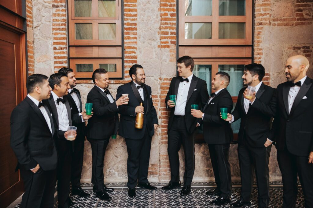 groom and groomsman toast in black suites