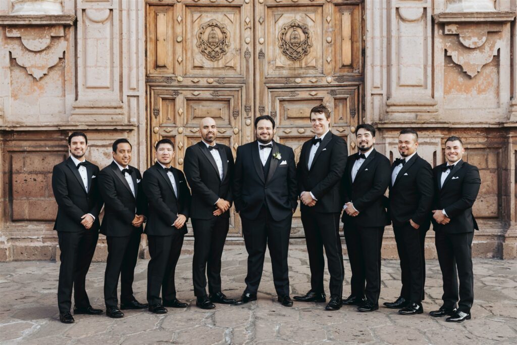groom with groomsmen in front of cathedral