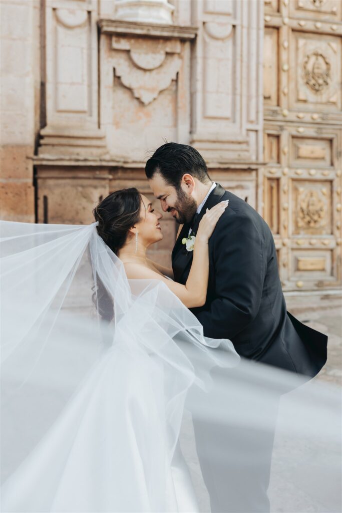 bride and groom hugging portrait with veil
