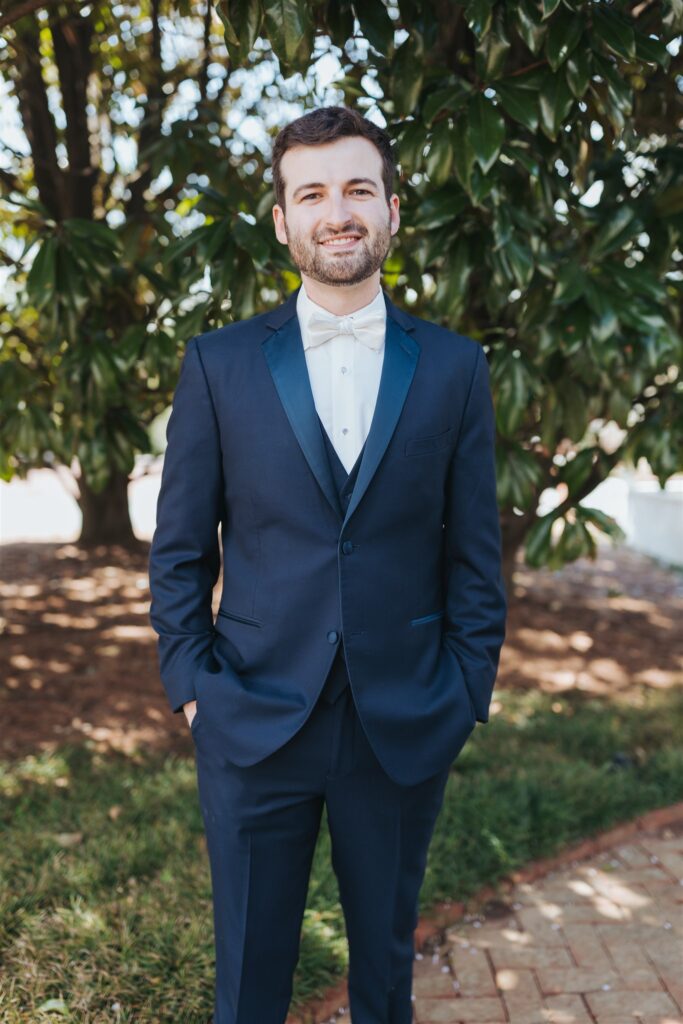 groom portrait in front of trees with blue suit
