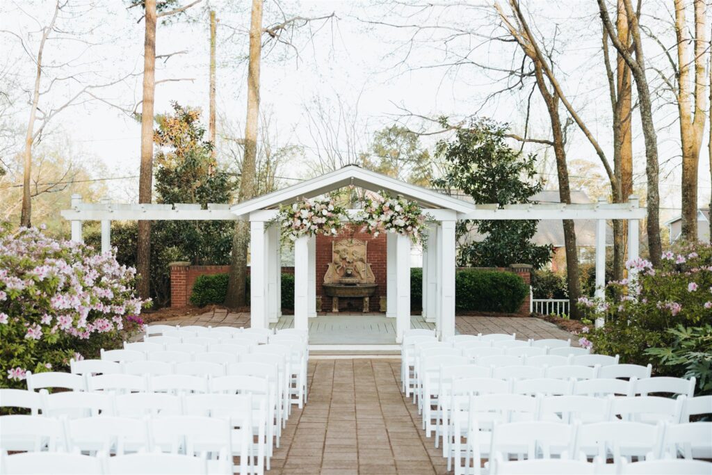 outdoor wedding venue in birmingham alabama with white chairs and floral arch