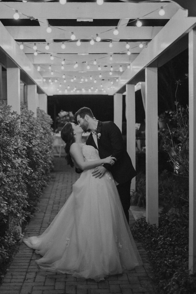 bride and groom kissing under lights