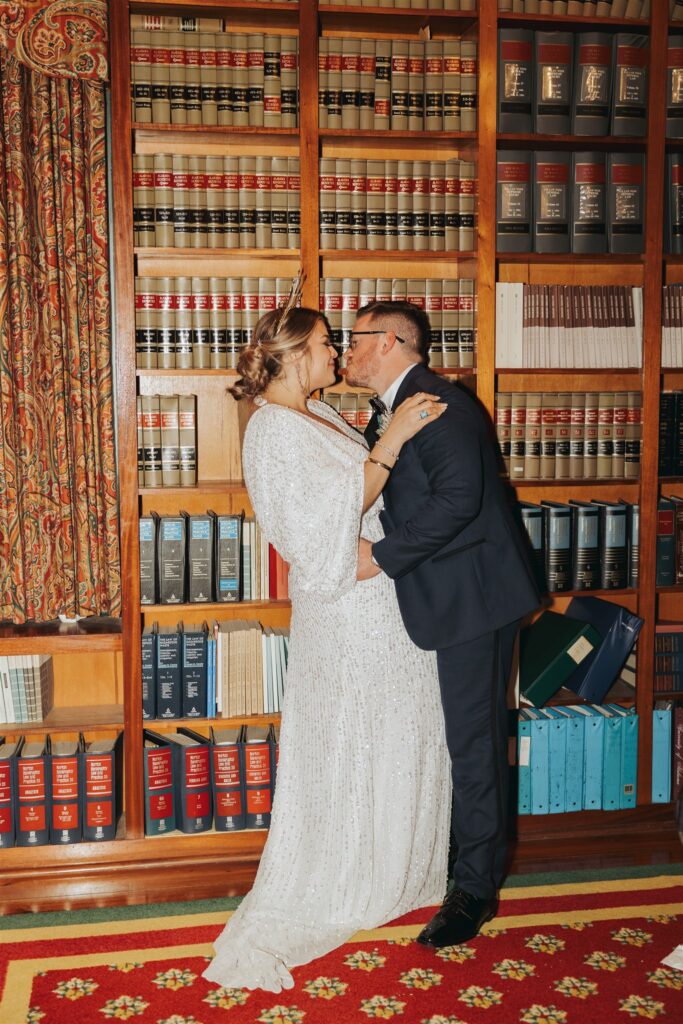 bride and groom kissing in library at the Ezell House in Downtown Mobile Alabama