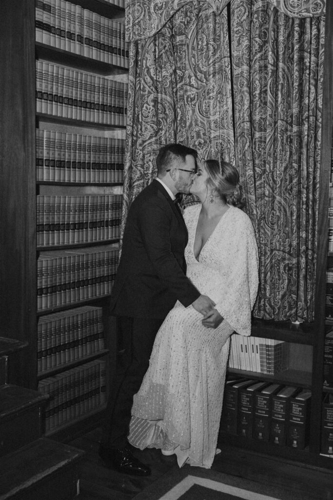 bride and groom kissing in library