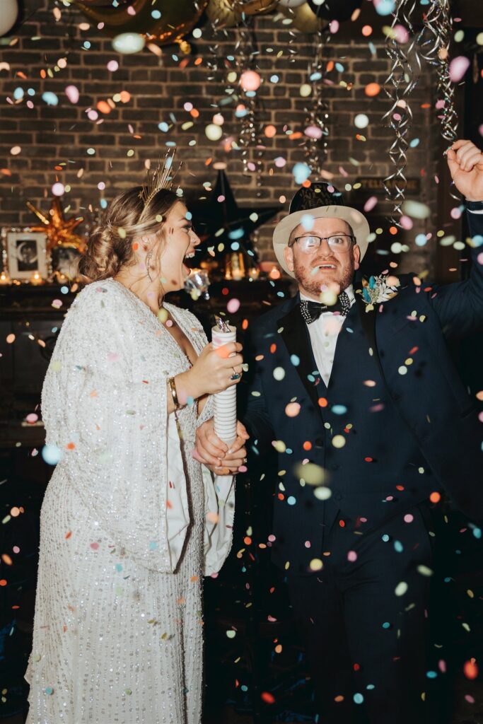 Bride and groom laughing at new years eve wedding with confetti at the Ezell House in Downtown Mobile Alabama