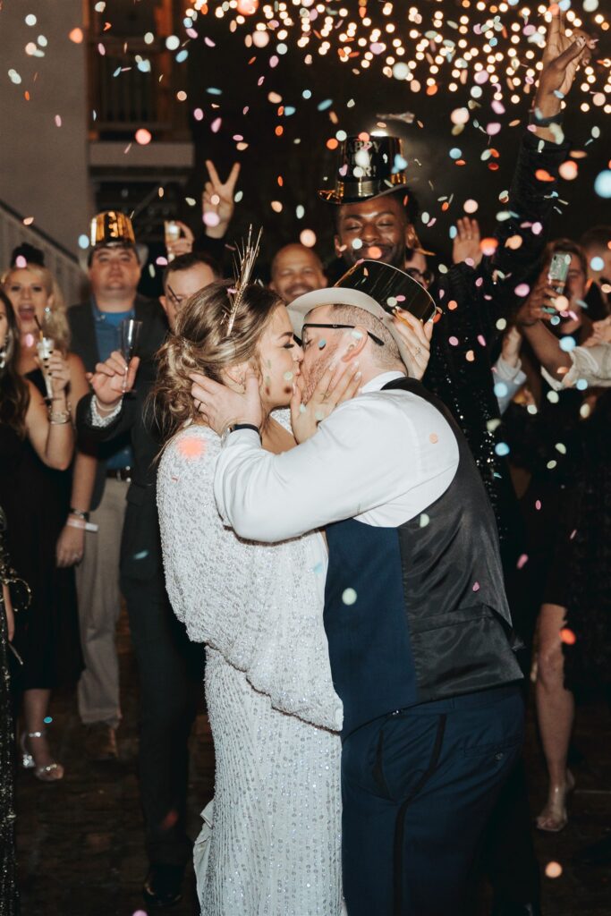 Bride and groom kissing on new years eve with confetti at the Ezell House in Downtown Mobile Alabama